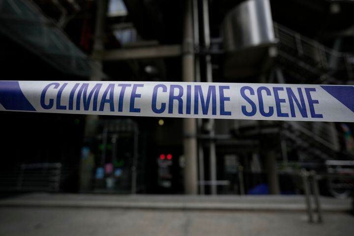 "Climate Crime Scene" tape put up by Extinction Rebellion climate change protesters is displayed during an action which closed down the Lloyds of London insurance company building for the day, in the City of London financial district of London, Tuesday, April 12, 2022. 