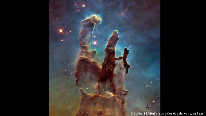 The Eagle Nebula’s Pillars of Creation. This image shows the pillars as seen in visible light, capturing the multi-coloured glow of gas clouds, wispy tendrils of dark cosmic dust, and the rust-coloured elephants’ trunks of the nebula’s famous pillars. The dust and gas in the pillars is seared by the intense radiation from young stars and eroded by strong winds from massive nearby stars. With these new images comes better contrast and a clearer view for astronomers to study how the structure of the pillars is changing over time.